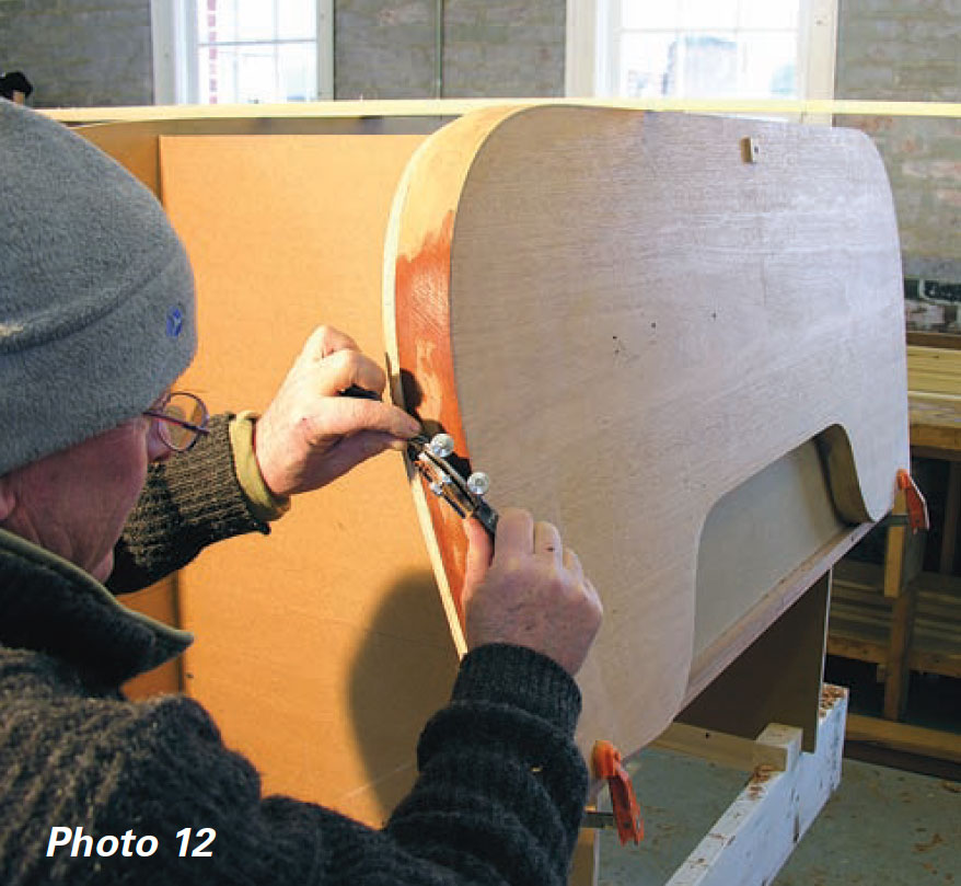 Boatbuilder uses a sharp spokeshave on a transom.