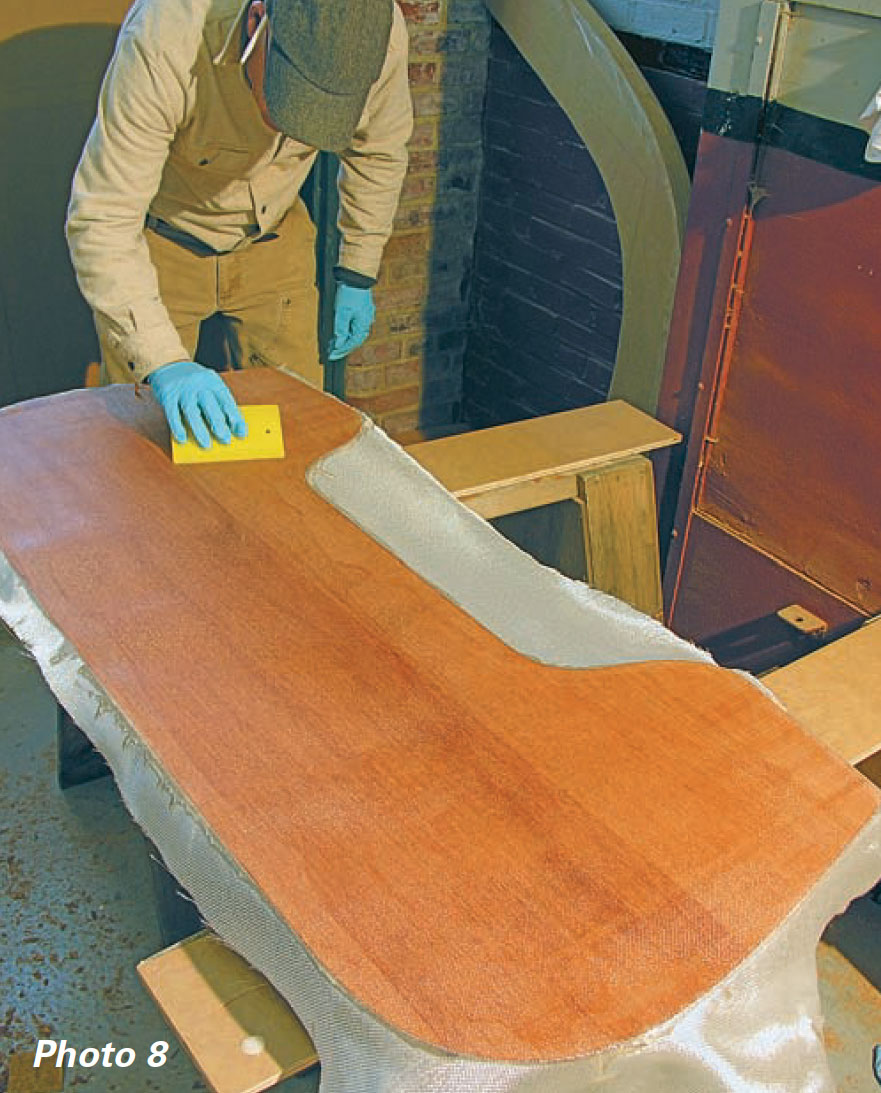 Man uses a sponge to apply epoxy to a piece of wood.