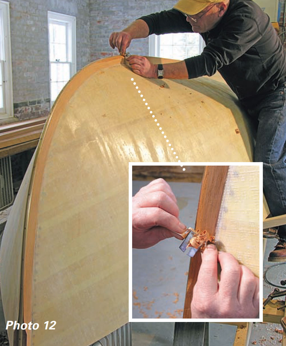 Zoomed in picture of a man using a spokeshave along a boat's outer stem.