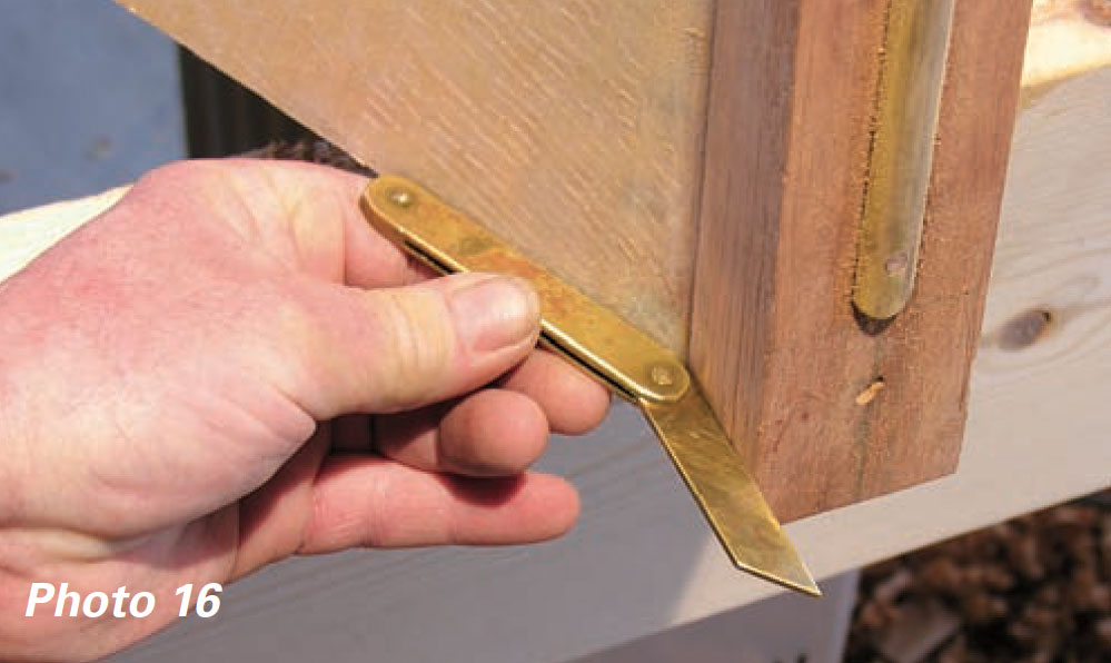 Hand holds brass bevel gauge to a block of wood.