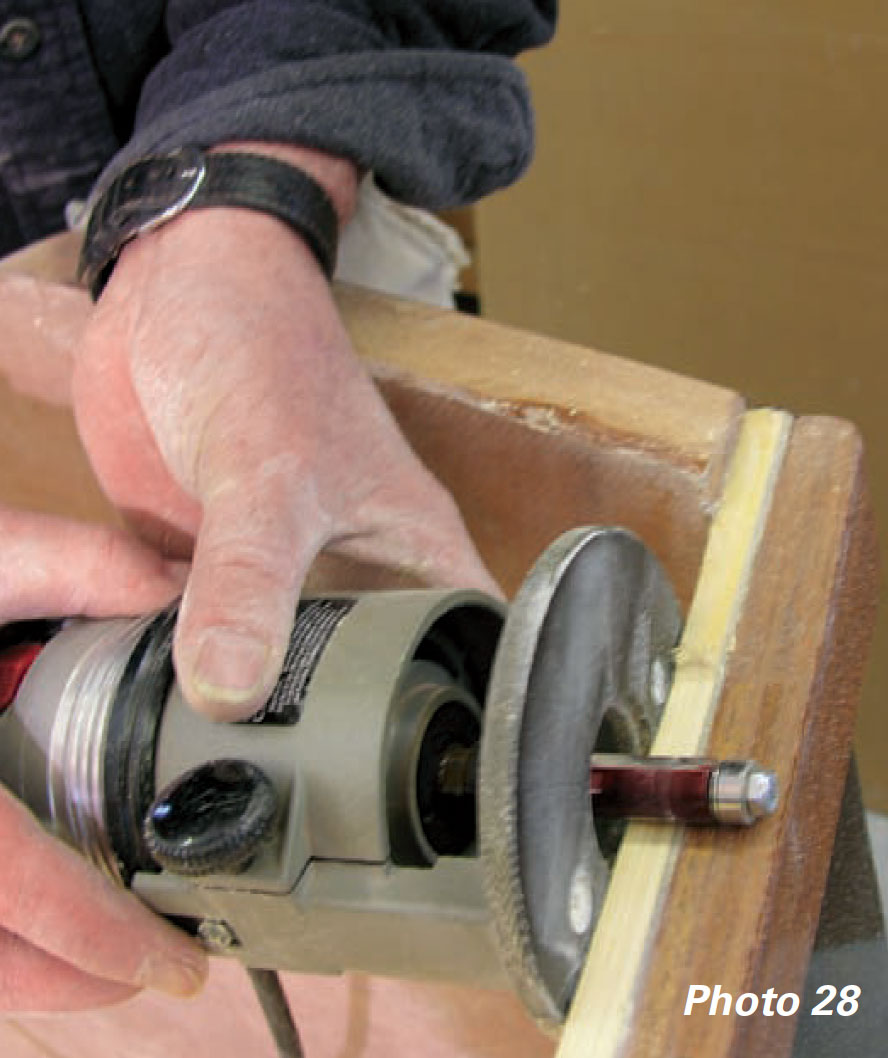 Hands holding a router cut along a piece of wood.