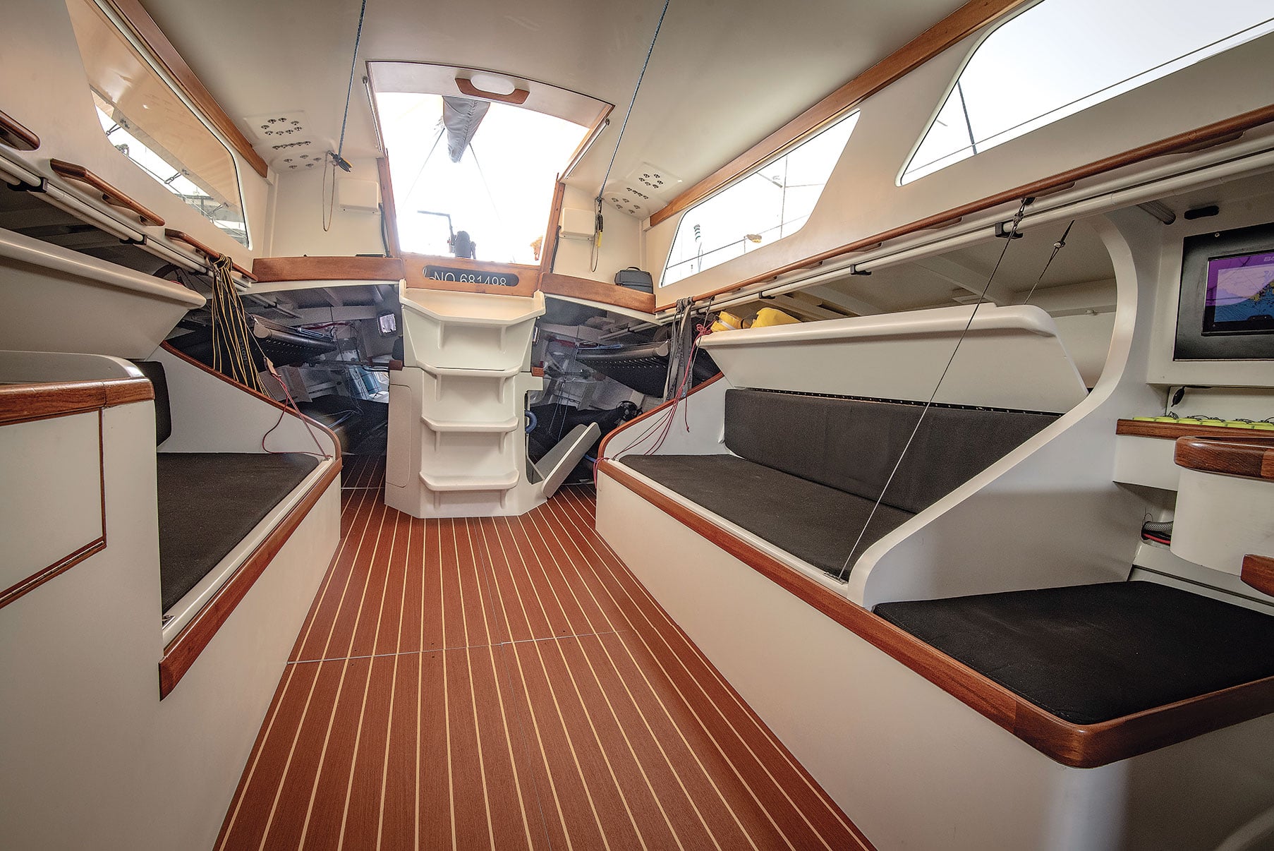 Cabin in a wooden racing yacht with four berths and a navigation desk.