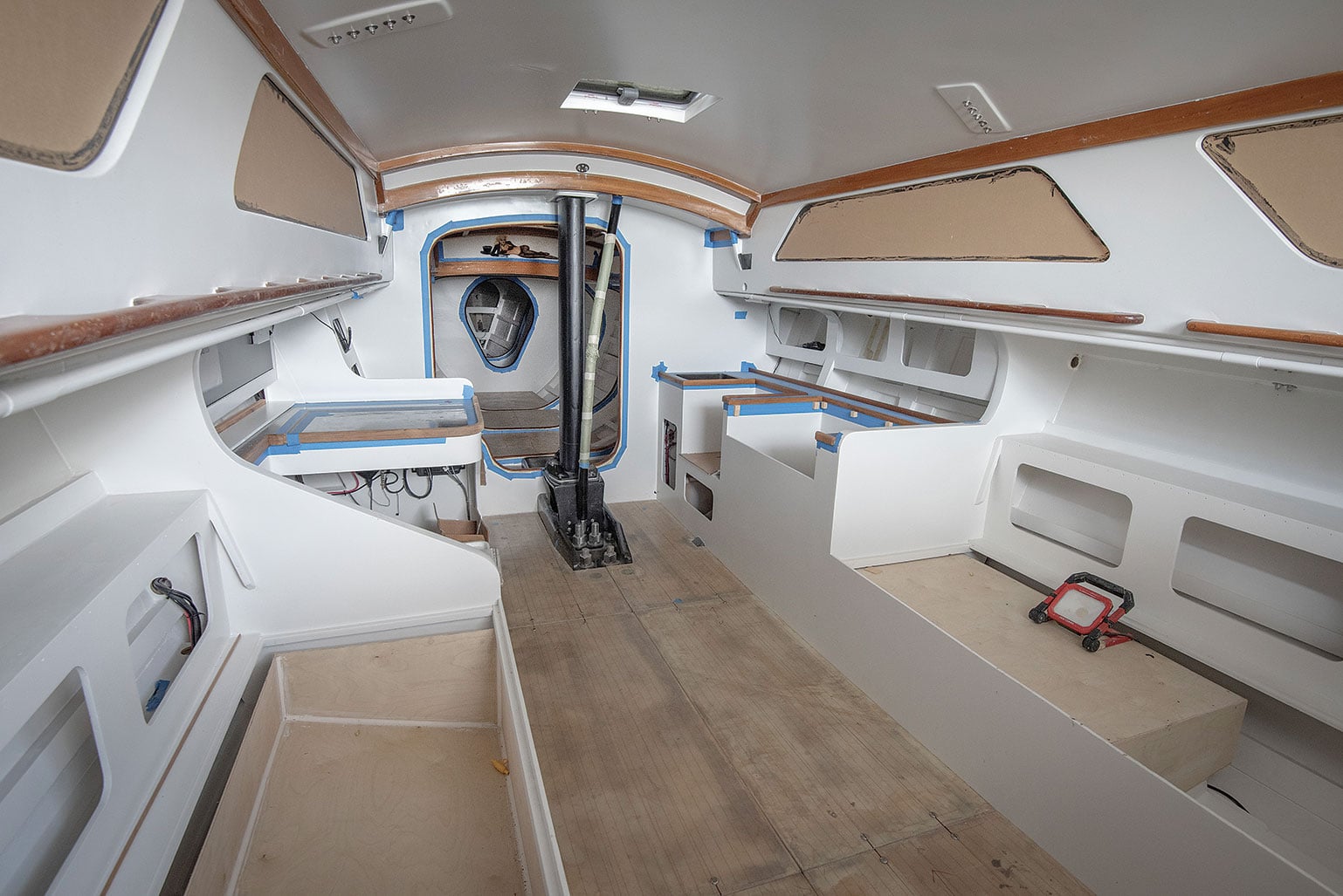 Refurbished interior of a wooden yacht with white-painted surfaces.