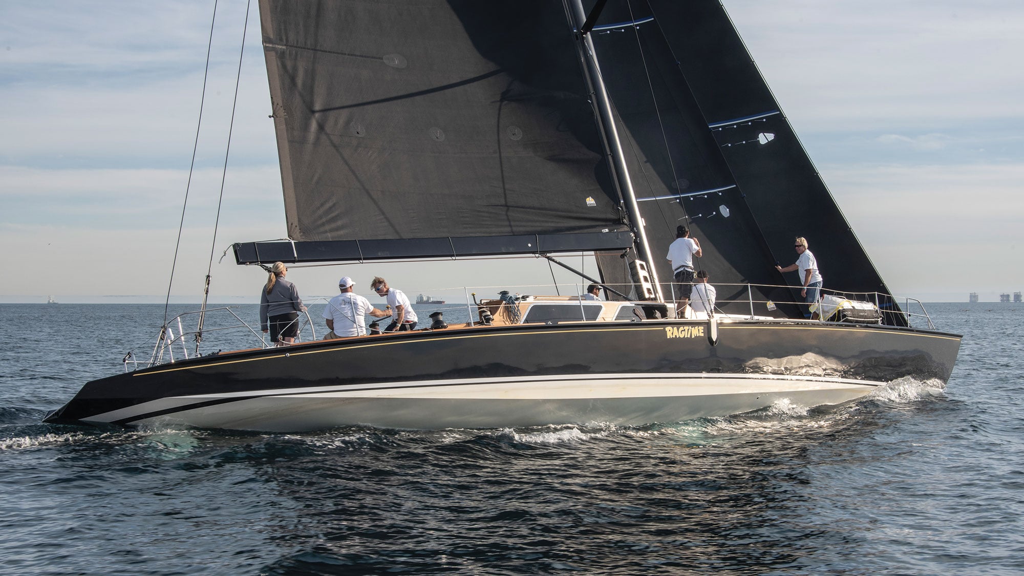 Side view of RAGTIME as it races along the water with sailors aboard.