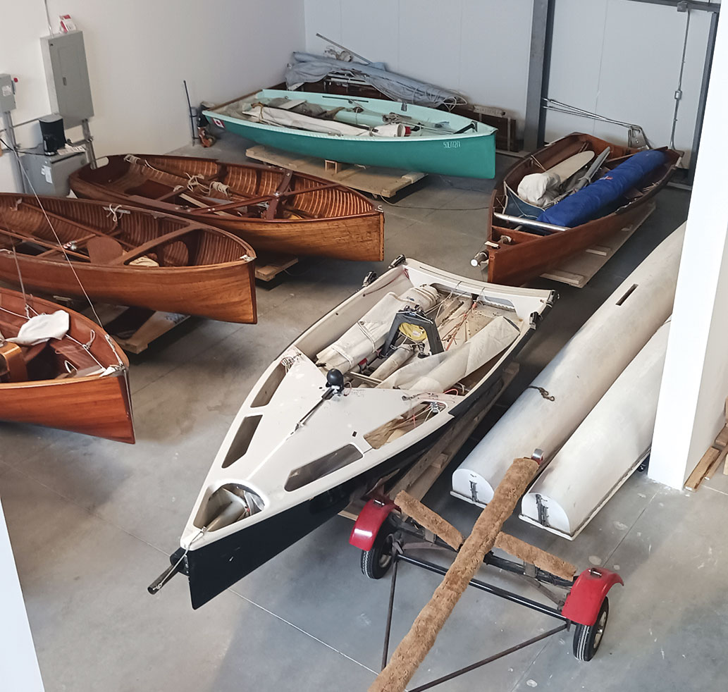 Several small wooden boats in storage.